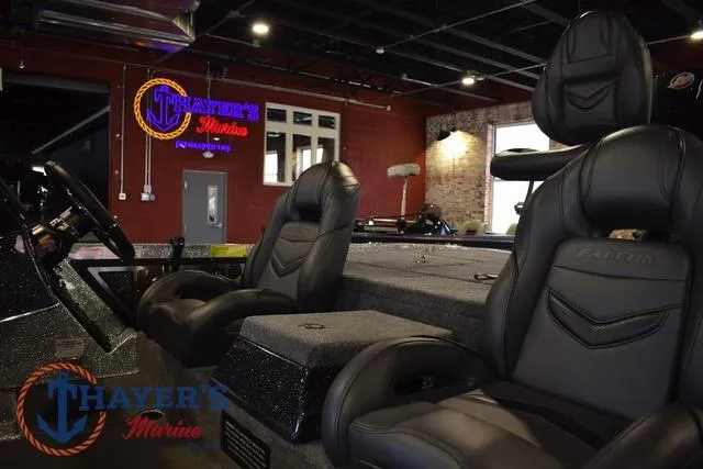 Slide: The Image of 2025 Falcon Bass Boats F20 TE interior with black leather seats at Thayer's Marine showroom. - 16