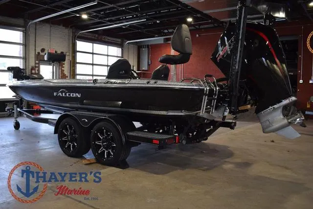 Slide: The Image of 2025 Falcon Bass Boats F20 TE in showroom, black exterior, dual axle trailer. - 5