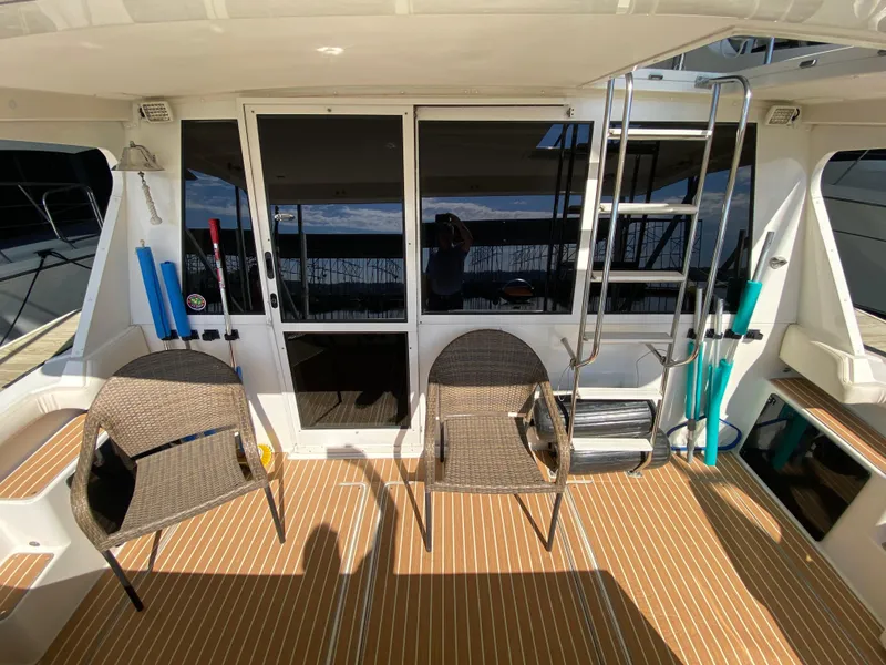 Slide: The Image of 2008 Meridian 490 Pilot House yacht deck with chairs and ladder. - 12