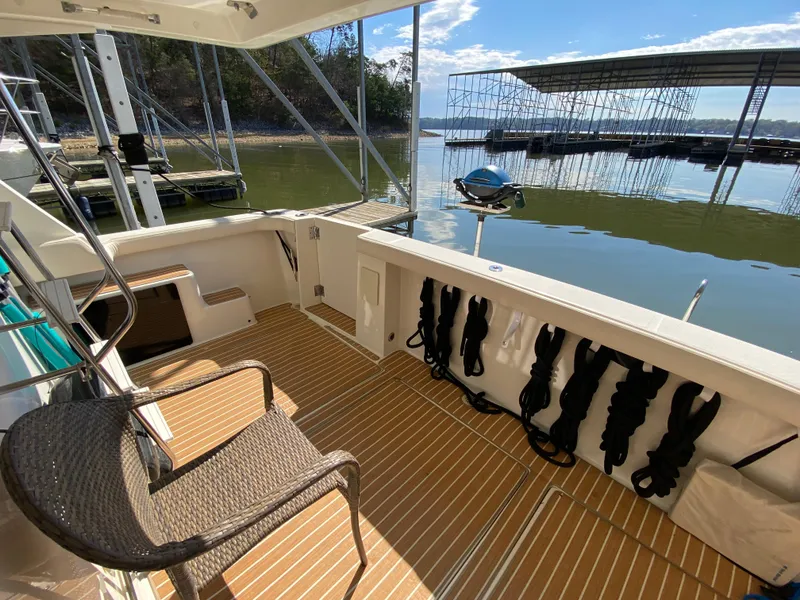 Slide: The Image of 2008 Meridian 490 Pilot House boat deck with seating, docked by calm waters. - 14