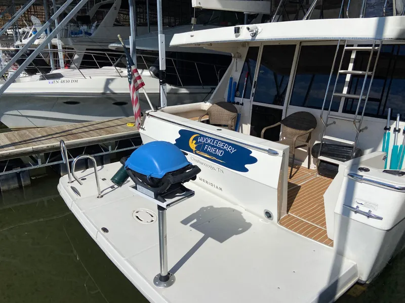 Slide: The Image of 2008 Meridian 490 Pilot House yacht docked, featuring outdoor seating and American flag. - 6