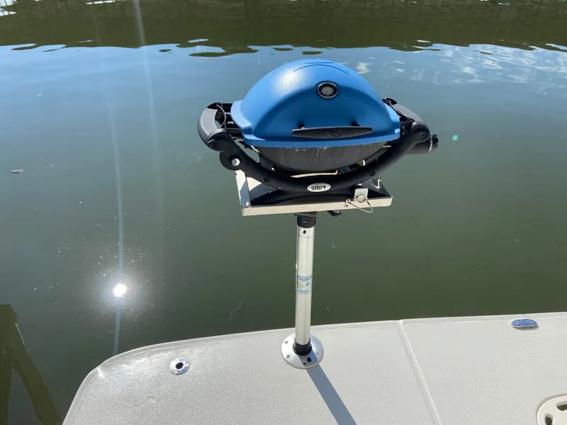 Slide: The Image of Blue grill mounted on a 2008 Meridian 490 Pilot House boat deck by the water. - 8