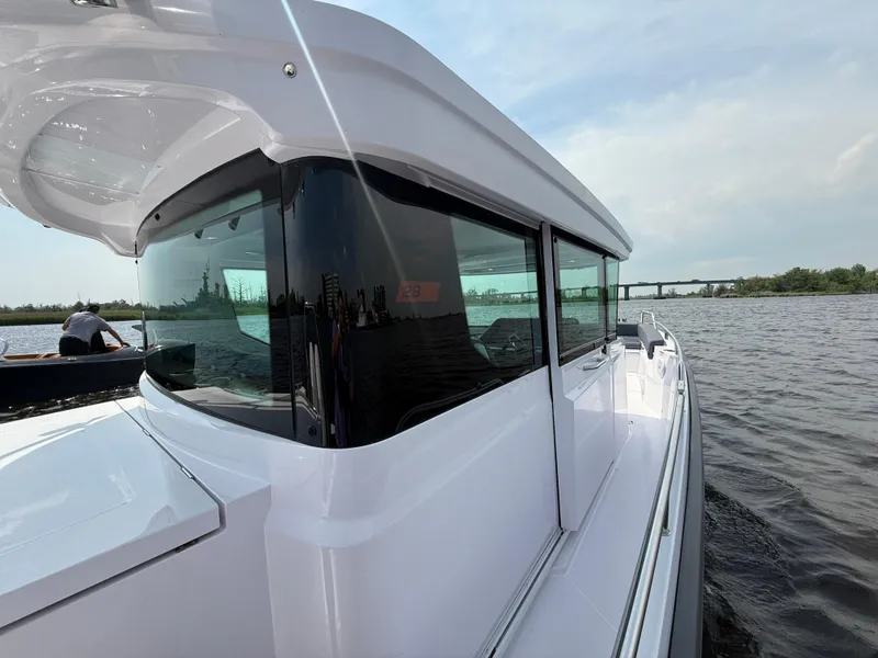 Slide: The Image of 2021 Axopar 28 CABIN boat on water, showcasing sleek design and modern features. - 10