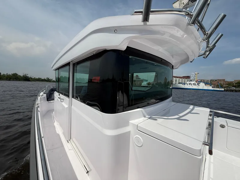 Slide: The Image of 2021 Axopar 28 CABIN boat on water, showcasing sleek design and modern features. - 11