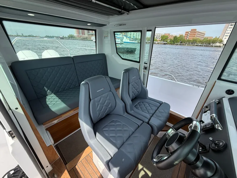 Slide: The Image of 2021 Axopar 28 CABIN interior with modern seating and waterfront view. - 15