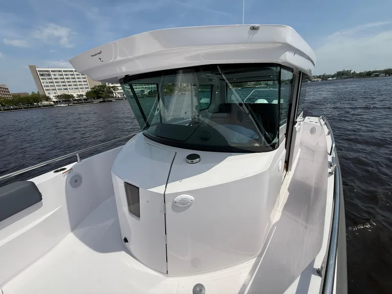 Slide: The Image of 2021 Axopar 28 CABIN boat on water, featuring sleek design and spacious cabin. - 17