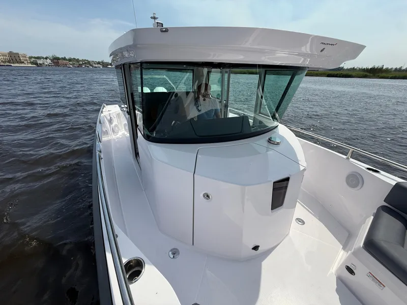 Slide: The Image of 2021 Axopar 28 CABIN boat on water, showcasing sleek design and modern features. - 19