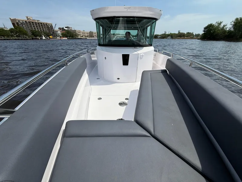 Slide: The Image of 2021 Axopar 28 CABIN boat with spacious seating on a calm waterway. - 21