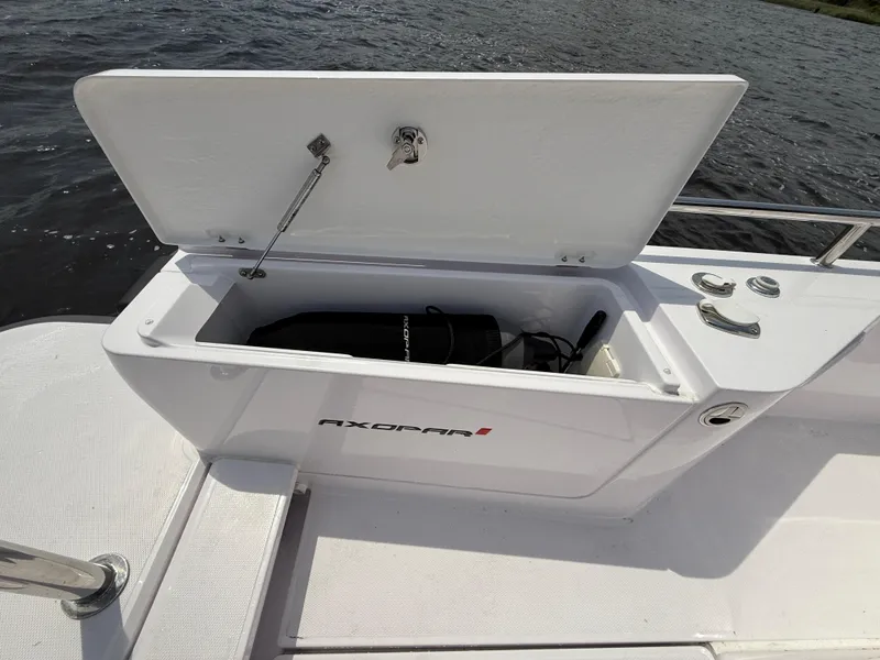 Slide: The Image of Open storage compartment on 2021 Axopar 28 CABIN boat, showing interior space. - 24