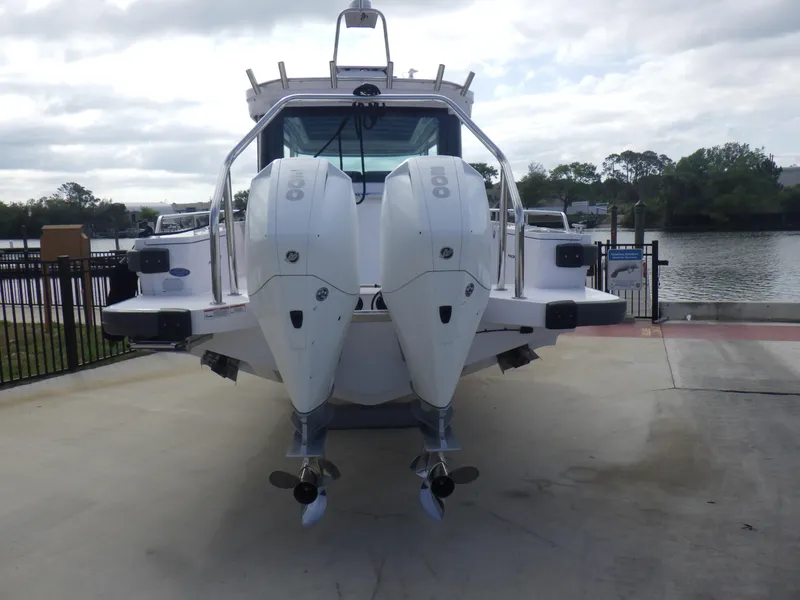 Slide: The Image of 2021 Axopar 28 CABIN boat with dual outboard engines, docked by a riverside. - 29