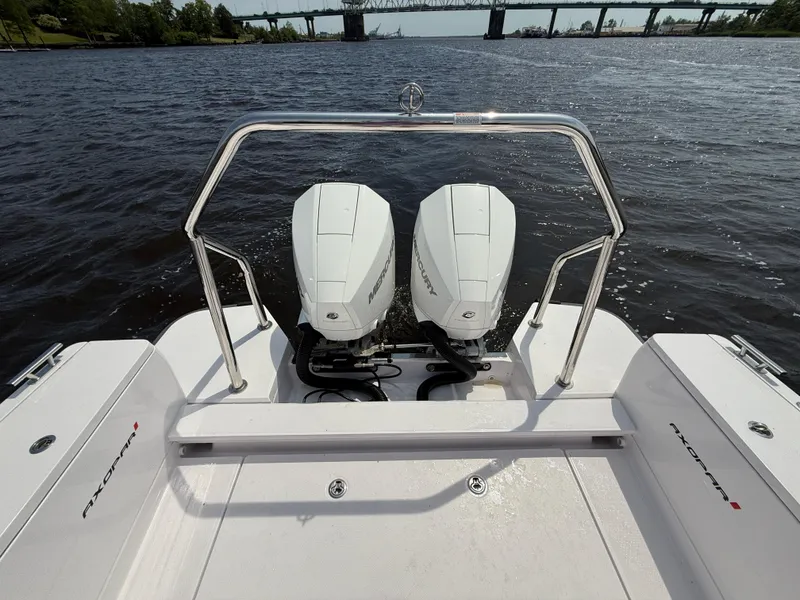 Slide: The Image of 2021 Axopar 28 CABIN boat with dual outboard engines on a river. - 5