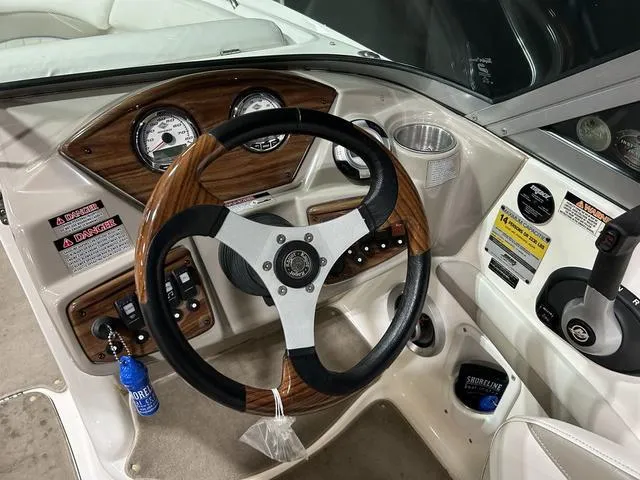 Slide: The Image of 2007 Kayot V220i boat dashboard with wood accents and steering wheel. - 15