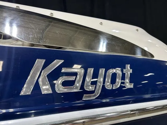 Slide: The Image of 2007 Kayot V220i boat with metallic logo on blue surface. - 23