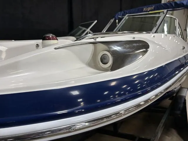 Slide: The Image of 2007 Kayot V220i boat with sleek design and blue accents in showroom. - 7