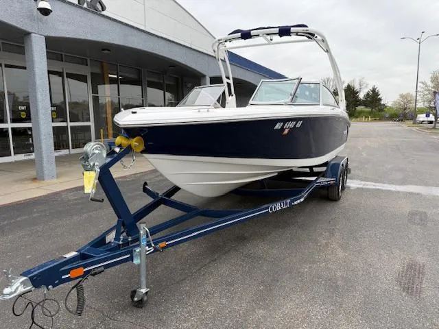 Slide: The Image of 2012 Cobalt 220S boat on trailer outside a building, ready for transport. - 2