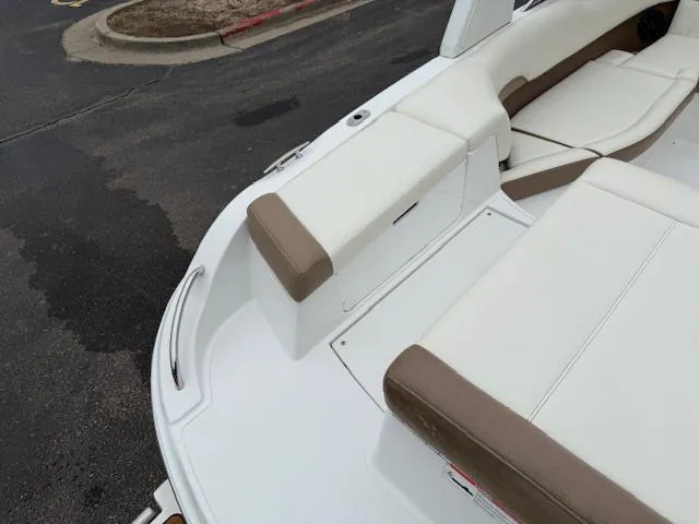 Slide: The Image of Cobalt 220S 2012 boat interior with white and brown seating, docked on pavement. - 5