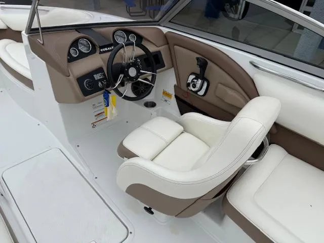 Slide: The Image of Interior of a 2012 Cobalt 220S boat featuring a sleek steering wheel and comfortable seating. - 8