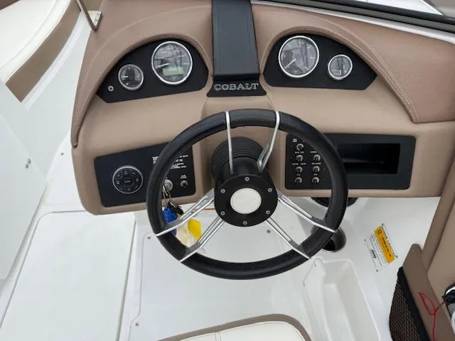 Slide: The Image of Steering wheel and dashboard of a 2012 Cobalt 220S boat, featuring gauges and controls. - 9