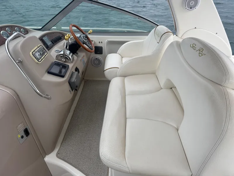 Slide: The Image of 2000 Sea Ray 340 Sundancer cockpit with beige seating and control panel. - 11