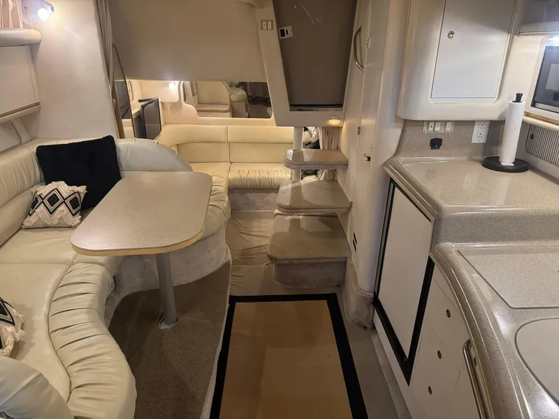 Slide: The Image of Interior of a 2000 Sea Ray 340 Sundancer yacht with seating and kitchenette. - 23