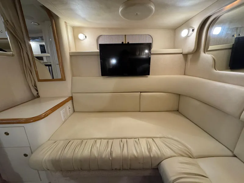 Slide: The Image of Interior of 2000 Sea Ray 340 Sundancer with beige seating and mounted TV. - 26