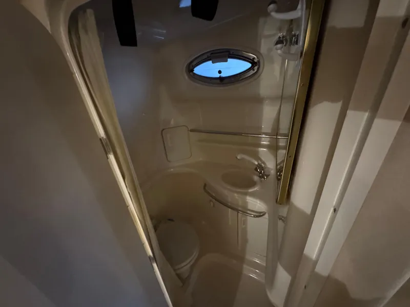 Slide: The Image of Compact bathroom in 2000 Sea Ray 340 Sundancer yacht with sink, toilet, and porthole. - 29