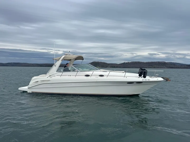 Slide: The Image of 2000 Sea Ray 340 Sundancer boat cruising on a calm lake under cloudy skies. - 6