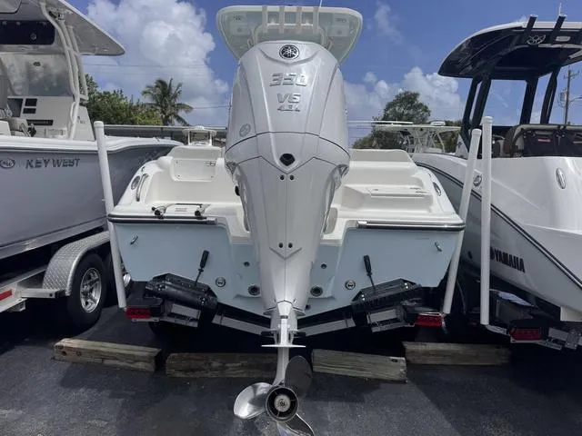 Slide: The Image of 2025 Key West 239 FSR boat with powerful outboard motor, parked outdoors. - 2