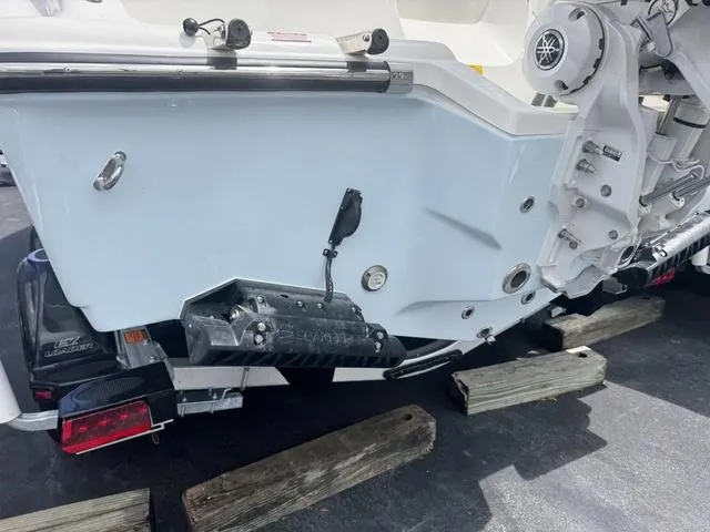 Slide: The Image of 2025 Key West 239 FSR boat stern on trailer, showcasing motor and trim tabs. - 3