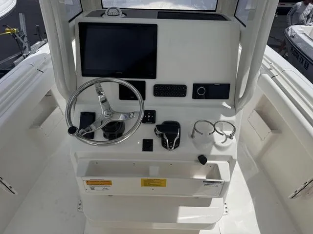 Slide: The Image of 2025 Key West 239 FSR boat console with steering wheel, touchscreen, and controls. - 6