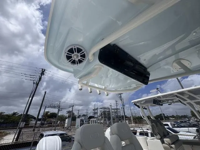 Slide: The Image of 2025 Key West 239 FSR boat interior with speaker and seating, under cloudy sky. - 7