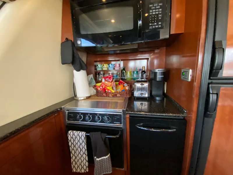 Slide: The Image of 2008 Meridian 490 Pilothouse kitchen with microwave, stove, and countertop appliances. - 23