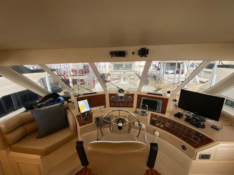 Slide: The Image of Pilothouse interior of 2008 Meridian 490, featuring steering wheel, navigation equipment, and panoramic windows. - 26