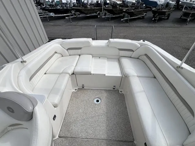 Slide: The Image of 2005 Stingray 220 DR boat interior with white cushioned seating and spacious layout. - 7