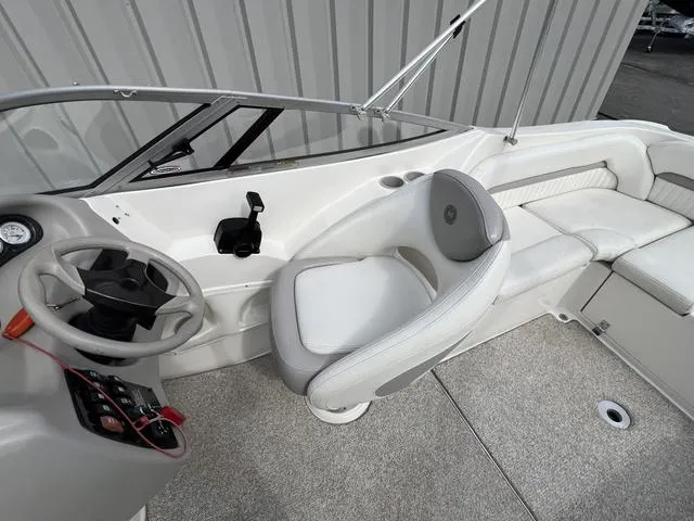 Slide: The Image of 2005 Stingray 220 DR boat interior with steering wheel and seating area. - 8