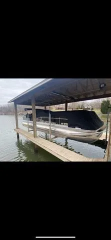Slide: The Image of 2011 Bennington 2550 RCL pontoon boat docked under a covered shelter. - 1