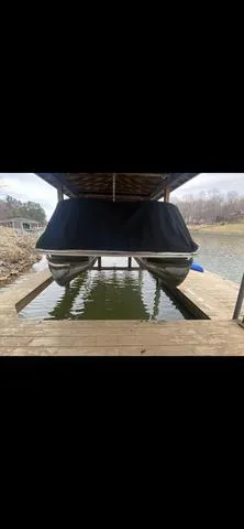 Slide: The Image of 2011 Bennington 2550 RCL pontoon boat docked under a covered structure. - 2