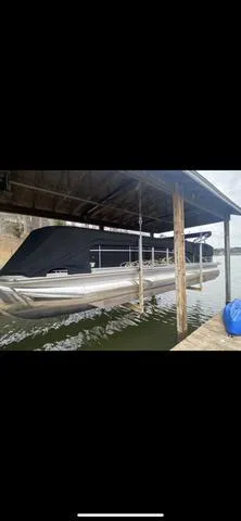 Slide: The Image of 2011 Bennington 2550 RCL pontoon boat docked under a wooden shelter. - 3