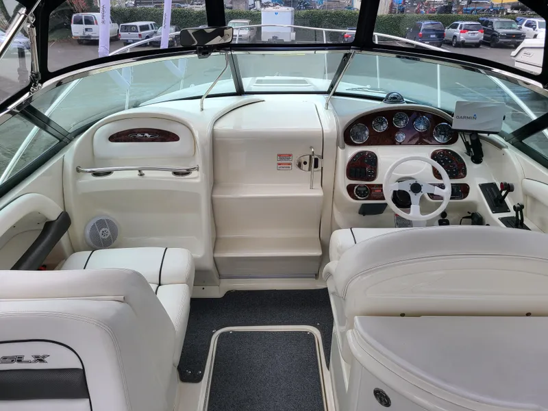 Slide: The Image of 2006 Sea Ray 290 Sun Sport boat interior with white seating and dashboard controls. - 10
