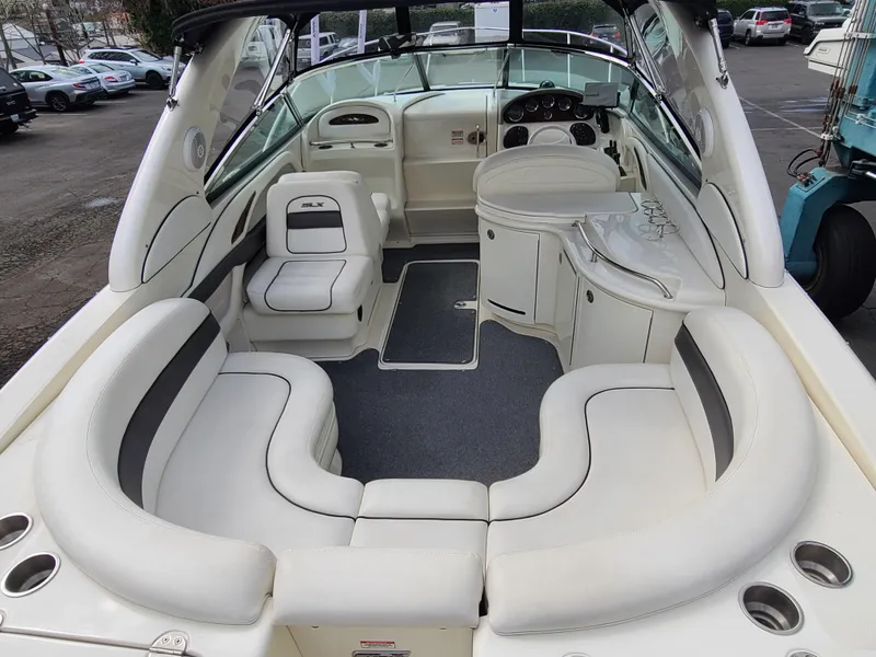 Slide: The Image of 2006 Sea Ray 290 Sun Sport boat interior with white seating and dashboard. - 13