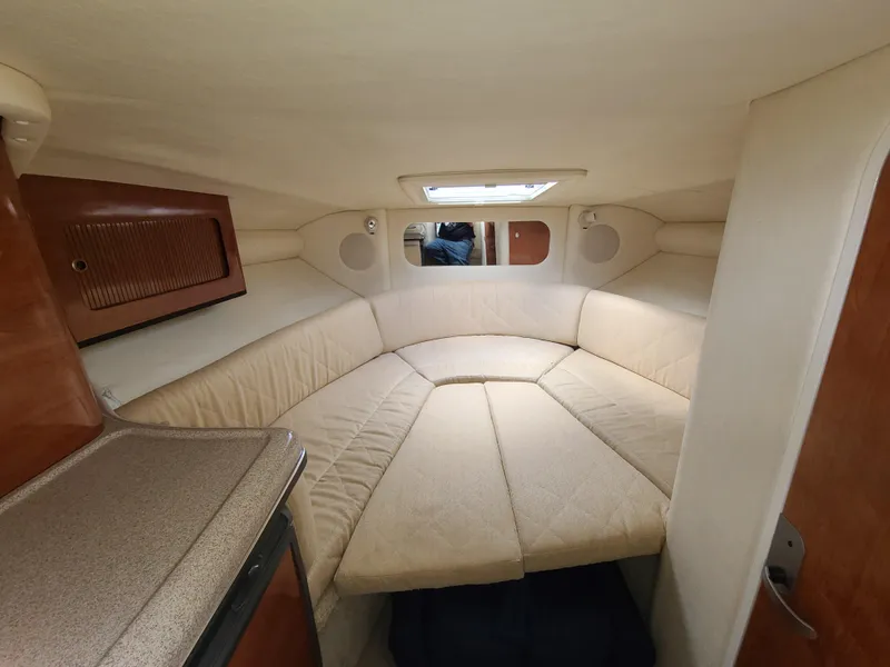 Slide: The Image of 2006 Sea Ray 290 Sun Sport cabin interior with beige seating and wood accents. - 20