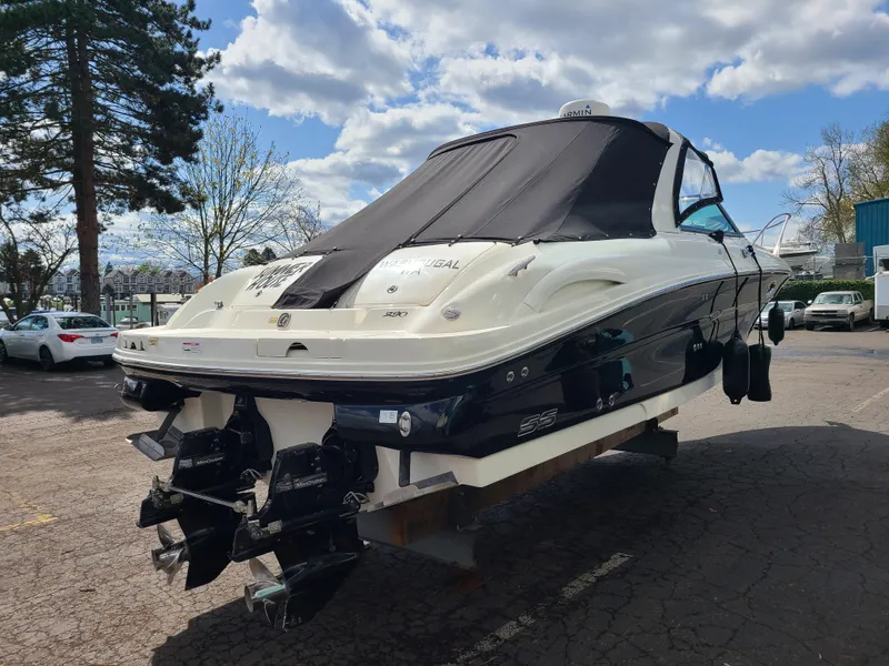 Slide: The Image of 2006 Sea Ray 290 Sun Sport boat with covered cockpit, parked outdoors under cloudy sky. - 3
