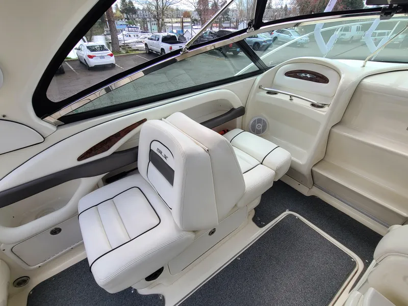 Slide: The Image of Interior of 2006 Sea Ray 290 Sun Sport boat with white seating and dashboard. - 9