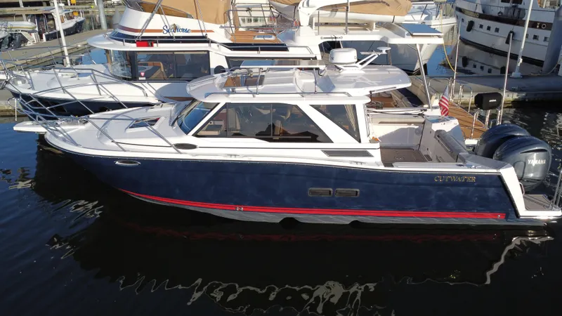 Slide: The Image of 2025 Cutwater C-288 Coupe boat docked in marina, side view. - 0