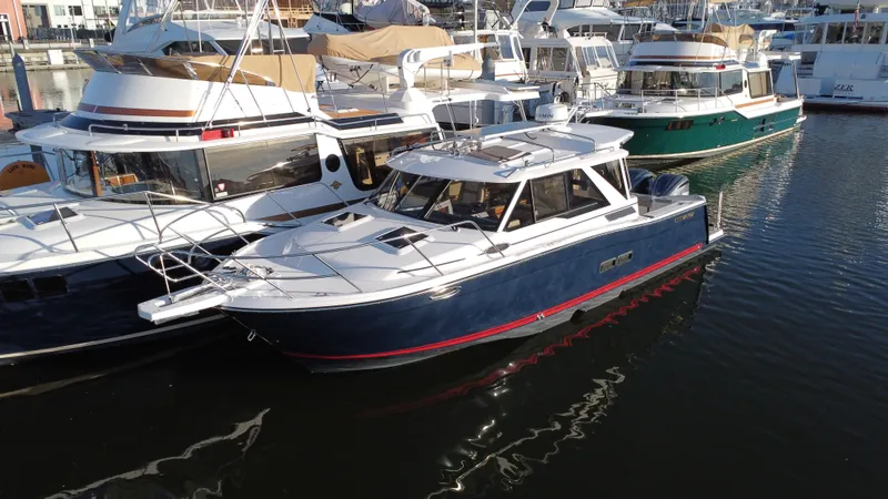 Slide: The Image of 2025 Cutwater C-288 Coupe boat docked in a marina, surrounded by other vessels. - 1