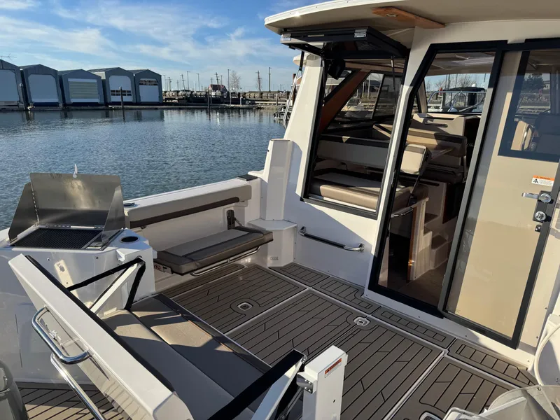 Slide: The Image of 2025 Cutwater C-288 Coupe boat interior with seating and grill by the water. - 11