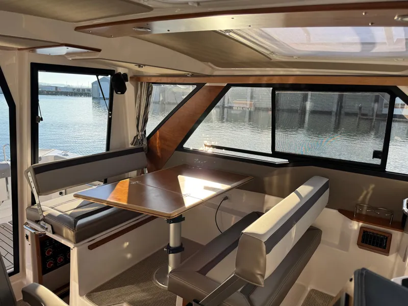 Slide: The Image of Interior of 2025 Cutwater C-288 Coupe boat with seating and table by windows. - 13