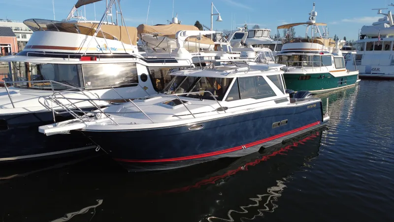 Slide: The Image of 2025 Cutwater C-288 Coupe docked among other boats in a marina. - 2