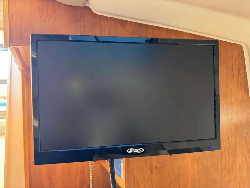 Slide: The Image of Jensen TV inside 2025 Cutwater C-288 Coupe boat, mounted on wooden interior wall. - 34