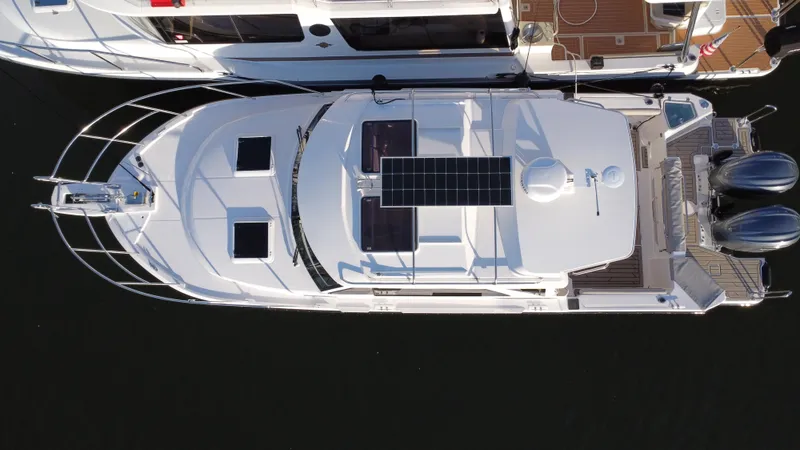 Slide: The Image of 2025 Cutwater C-288 Coupe boat, aerial view, docked with solar panels and twin engines. - 5